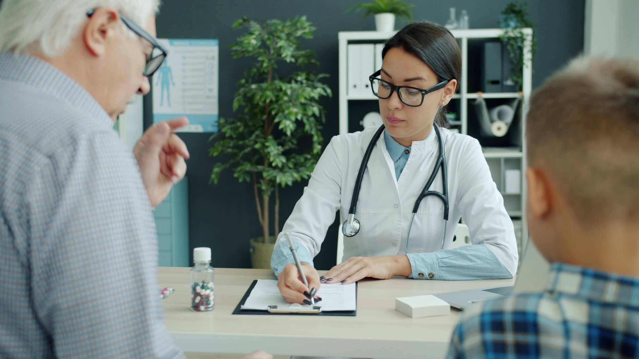 Médico atendiendo a paciente en consulta de seguro de salud privado en España