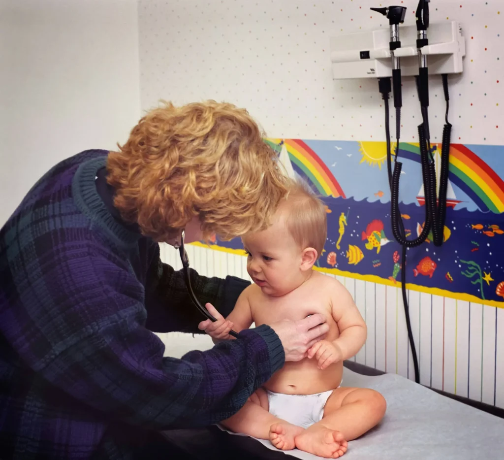 Médico atendiendo a un niño pequeño en consulta médica durante un viaje