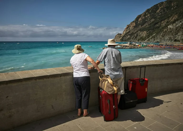 Pareja mayor de 65 años con maletas en el aeropuerto lista para viajar con seguro de viaje